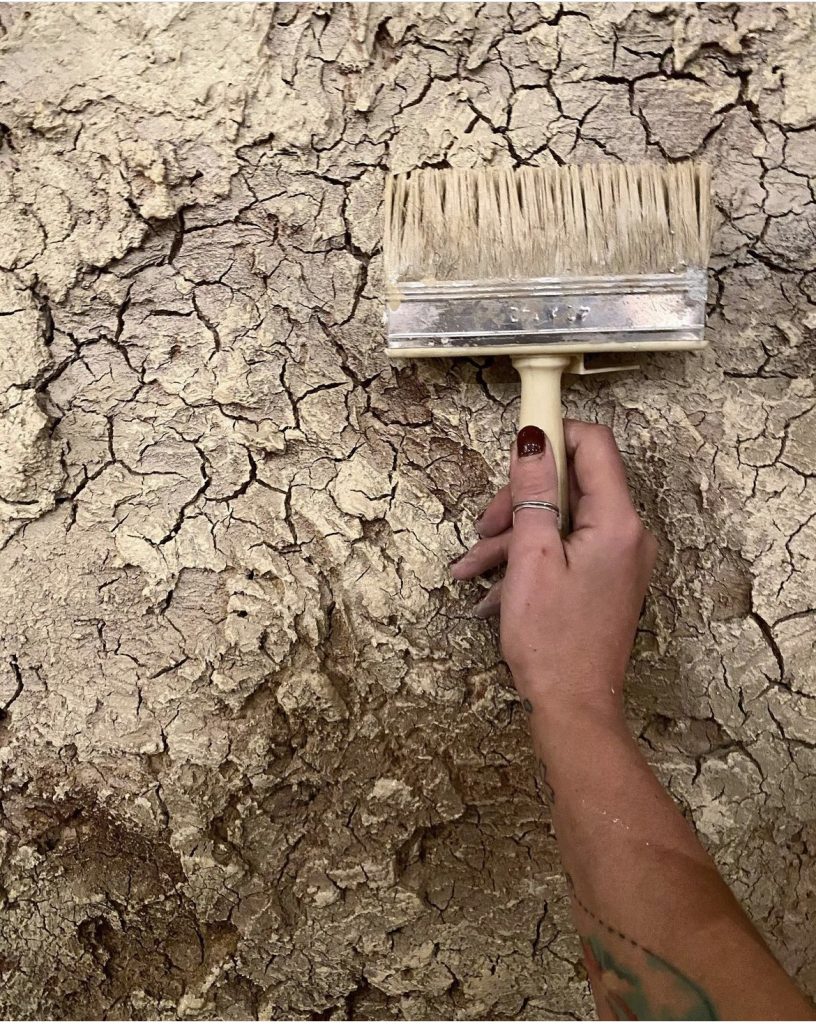 Mural Way artist creating textured wall finish during decoration process for Dubai venue